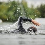 Man Swimming in Lake with Water Splashes