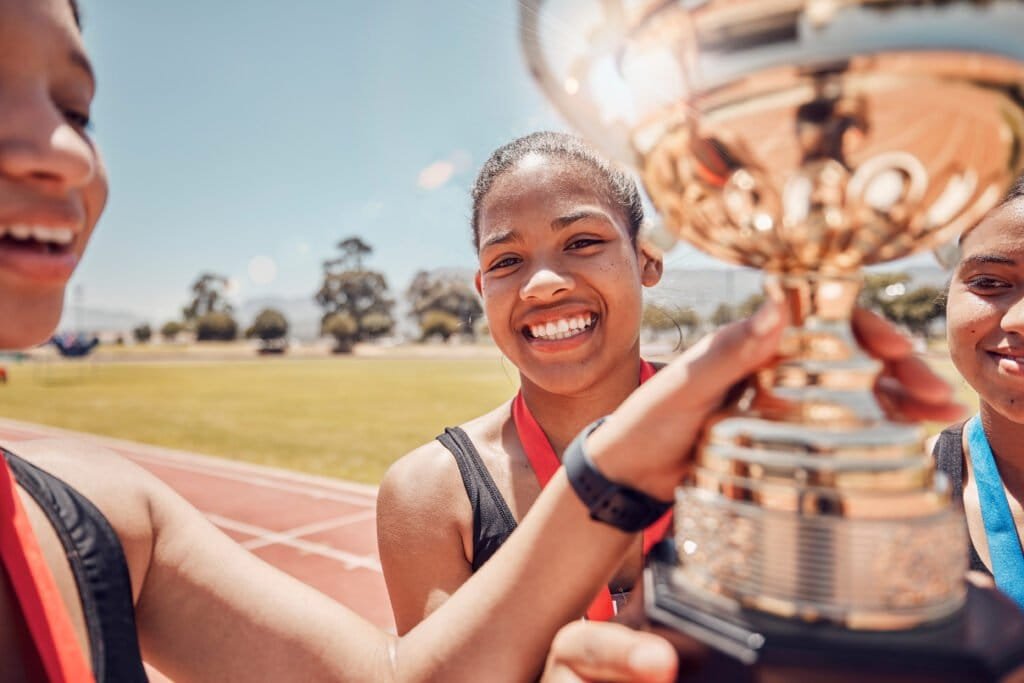 Winner runner, women holding trophy or fitness for happy team race, sport success or celebration