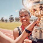 Winner runner, women holding trophy or fitness for happy team race, sport success or celebration