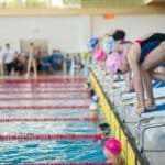 Swimmer girl start from the starting table in the pool