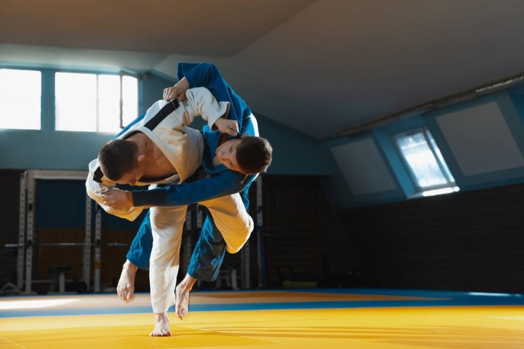 Two young judo fighters in kimono training martial arts in the gym with expression, in action and motion